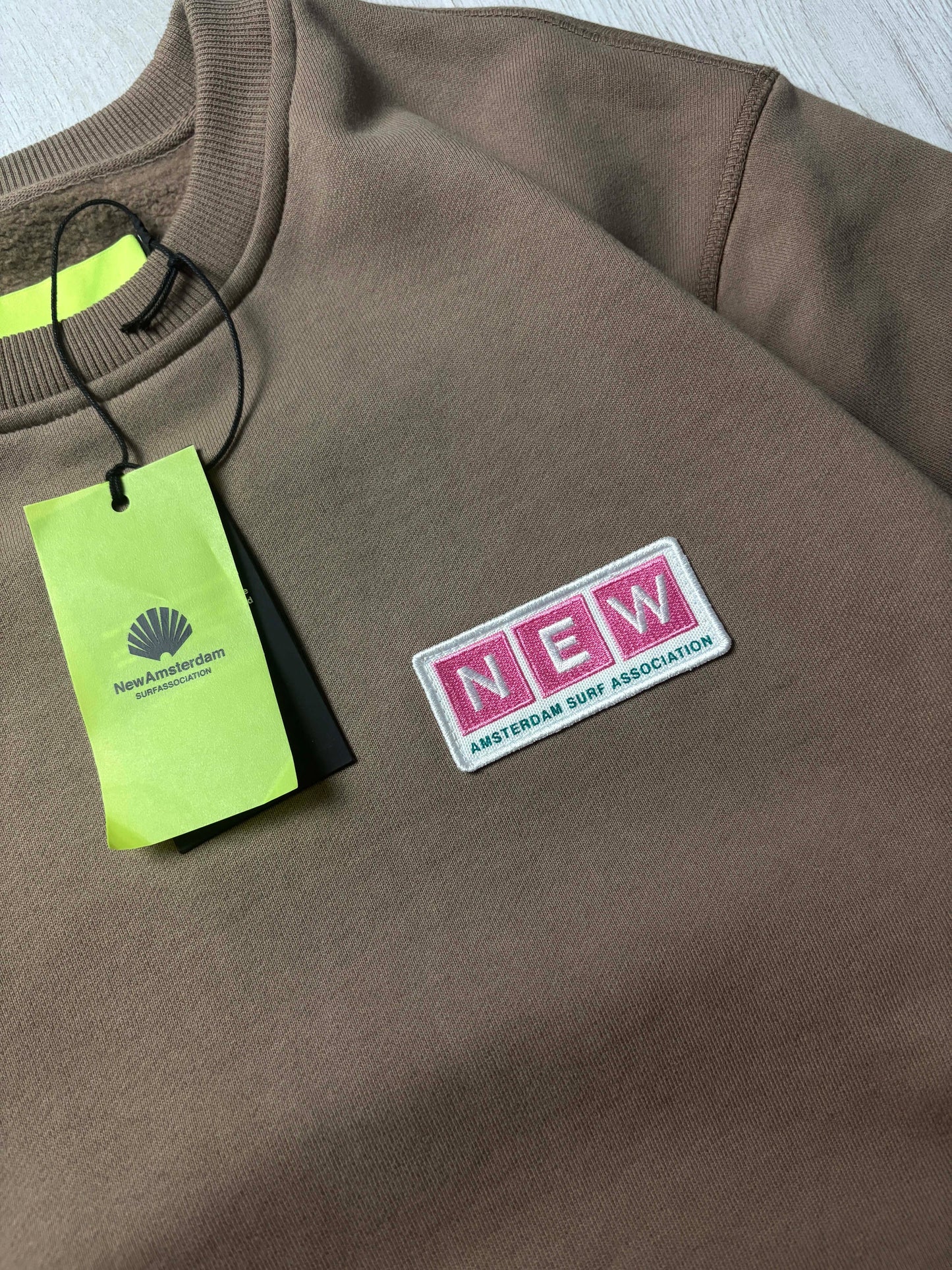 π New Amsterdam Surf Association Sweater Bruin β Nieuwstaat β Maten S & L